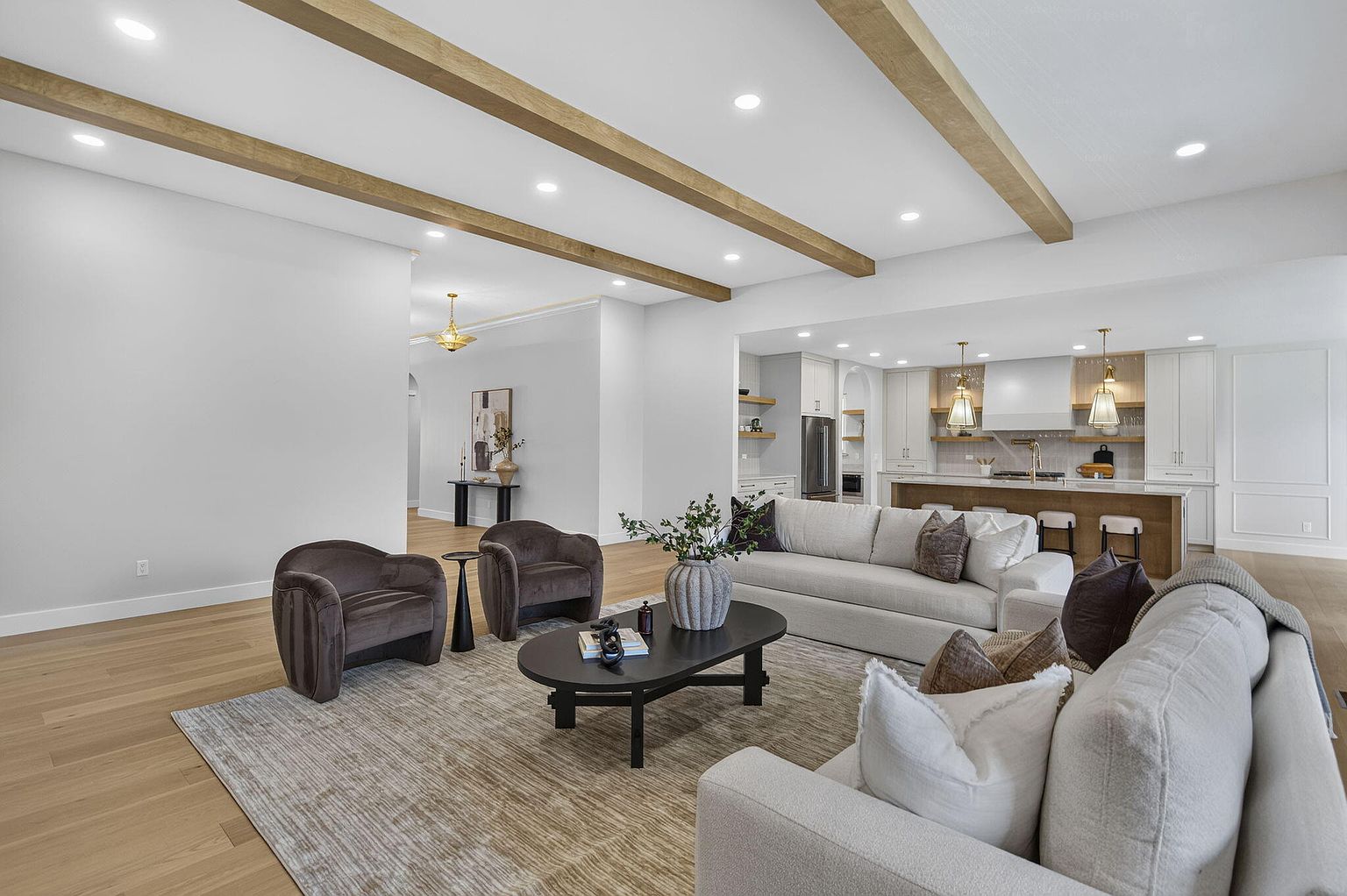 Living room with velvet swivel chairs and oval coffee table looking toward the kitchen after staging at 2050 N Silver Charm Ave, Springfield, MO