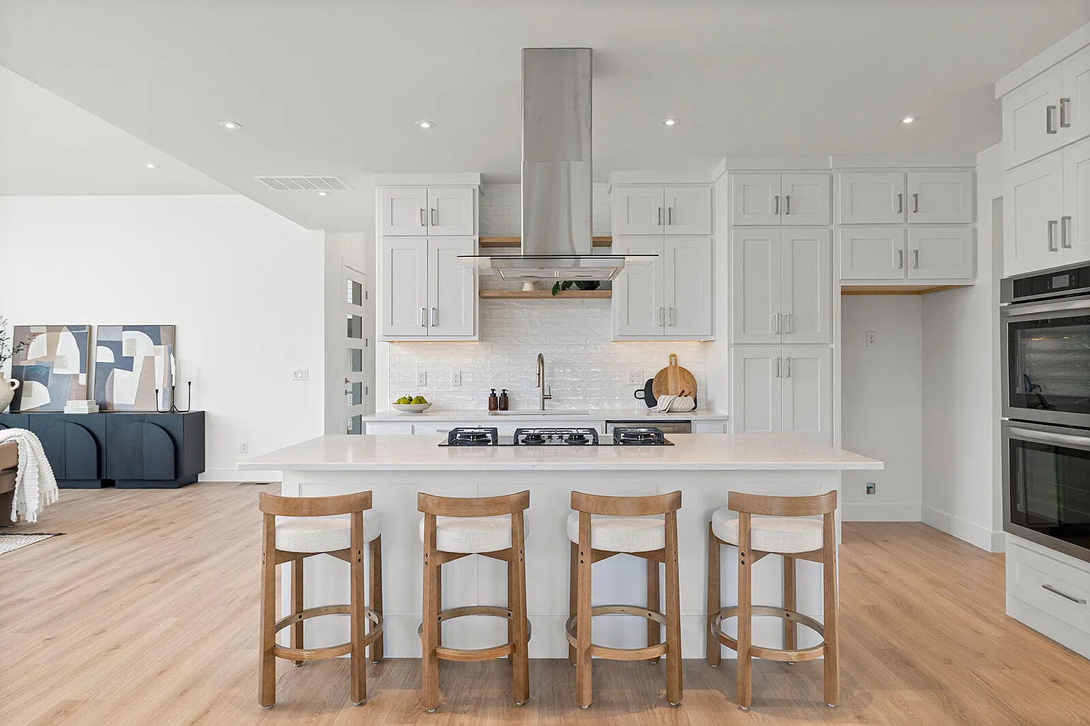 Kitchen island with four bar stools and range hood after staging - 2807 S 14th Ave, Ozark, MO
