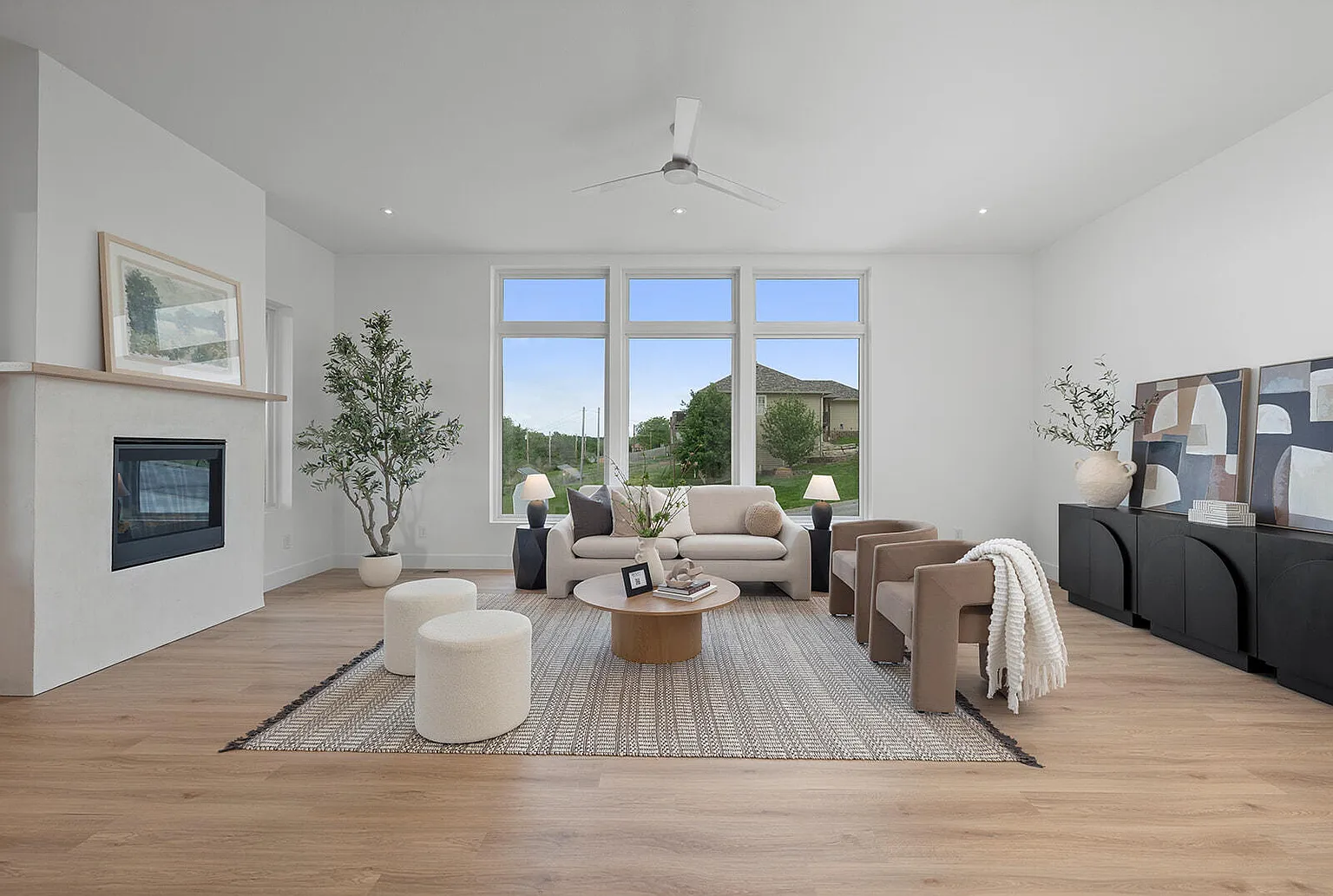Living room wide angle with fireplace and large windows after staging - 2807 S 14th Ave, Ozark, MO