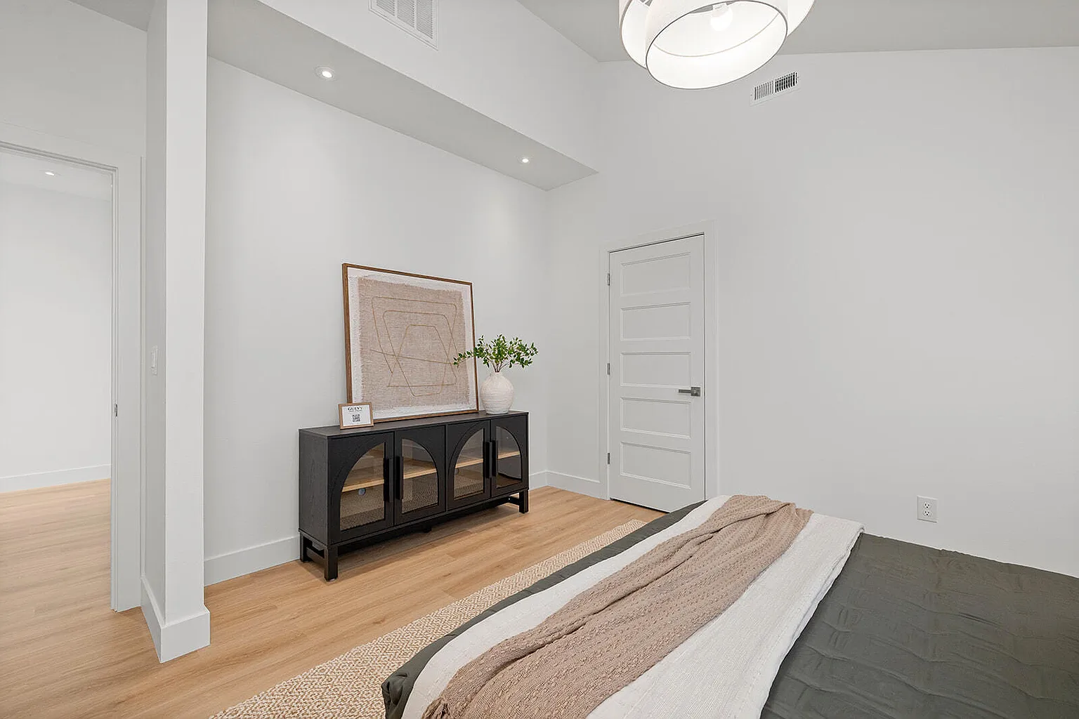 Master bedroom with black sideboard and framed art after staging - 2807 S 14th Ave, Ozark, MO