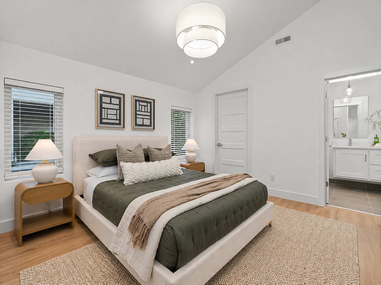 Master bedroom with vaulted ceiling and ensuite view after staging - 2807 S 14th Ave, Ozark, MO