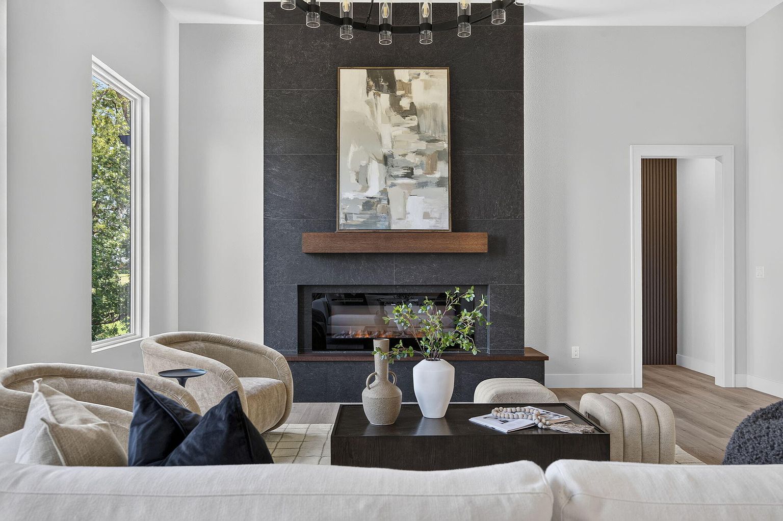 Black tile fireplace with wood mantel, abstract art and styled coffee table - 346 Sunset Dr, Saddlebrooke, MO home staging