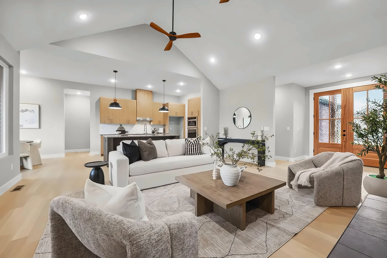 Open-concept great room with living area, wood front door and kitchen beyond after vacant home staging at 5048 Swale, Springfield, MO