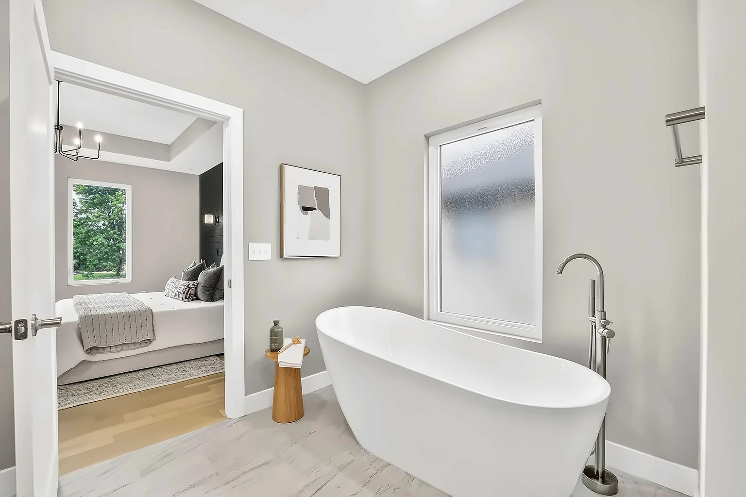Primary bathroom with freestanding soaking tub and frosted window off the bedroom - 5048 Swale, Springfield, MO home staging