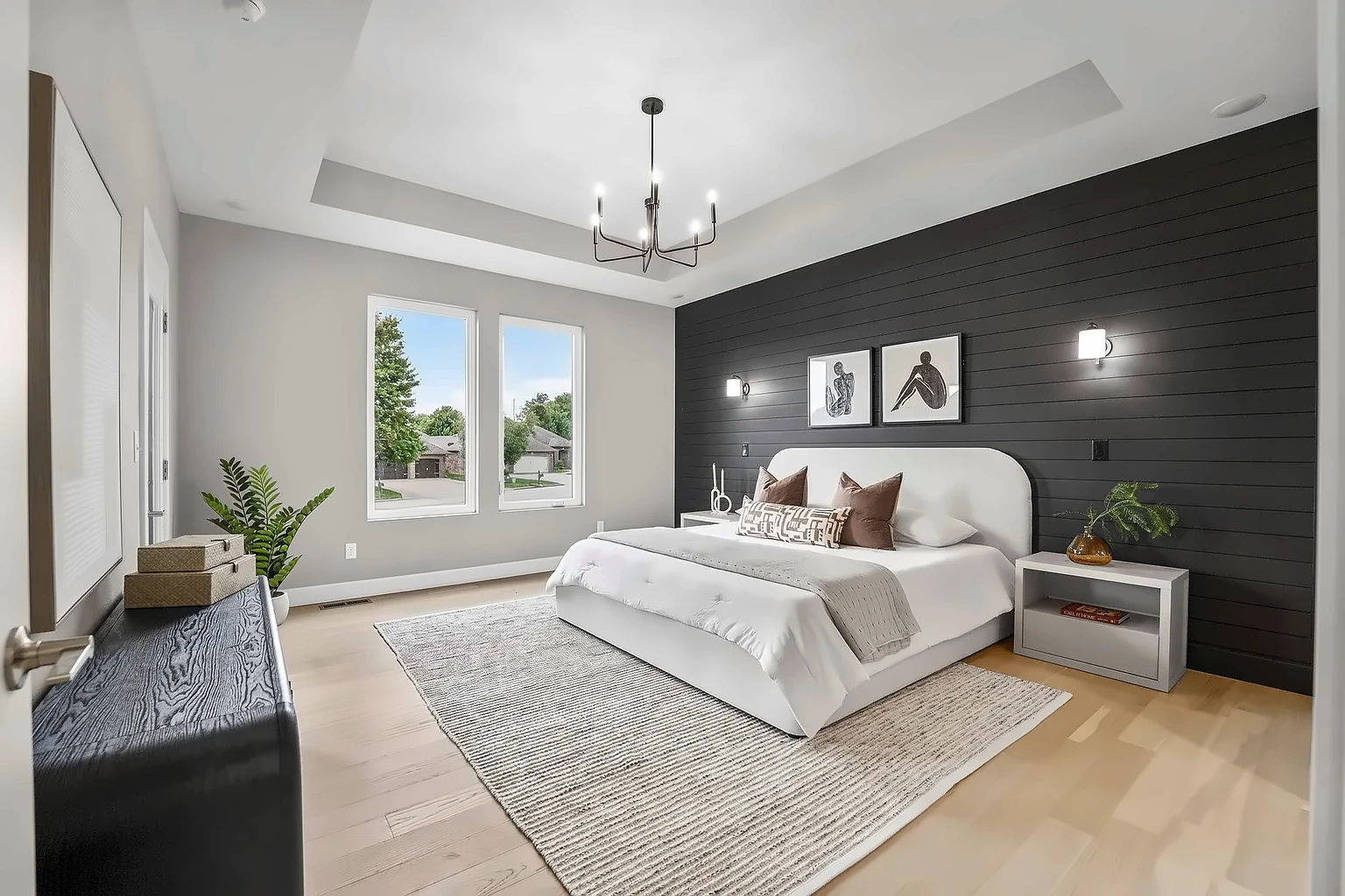 Primary bedroom with black shiplap accent wall, upholstered bed and tray ceiling after vacant home staging at 5048 Swale, Springfield, MO