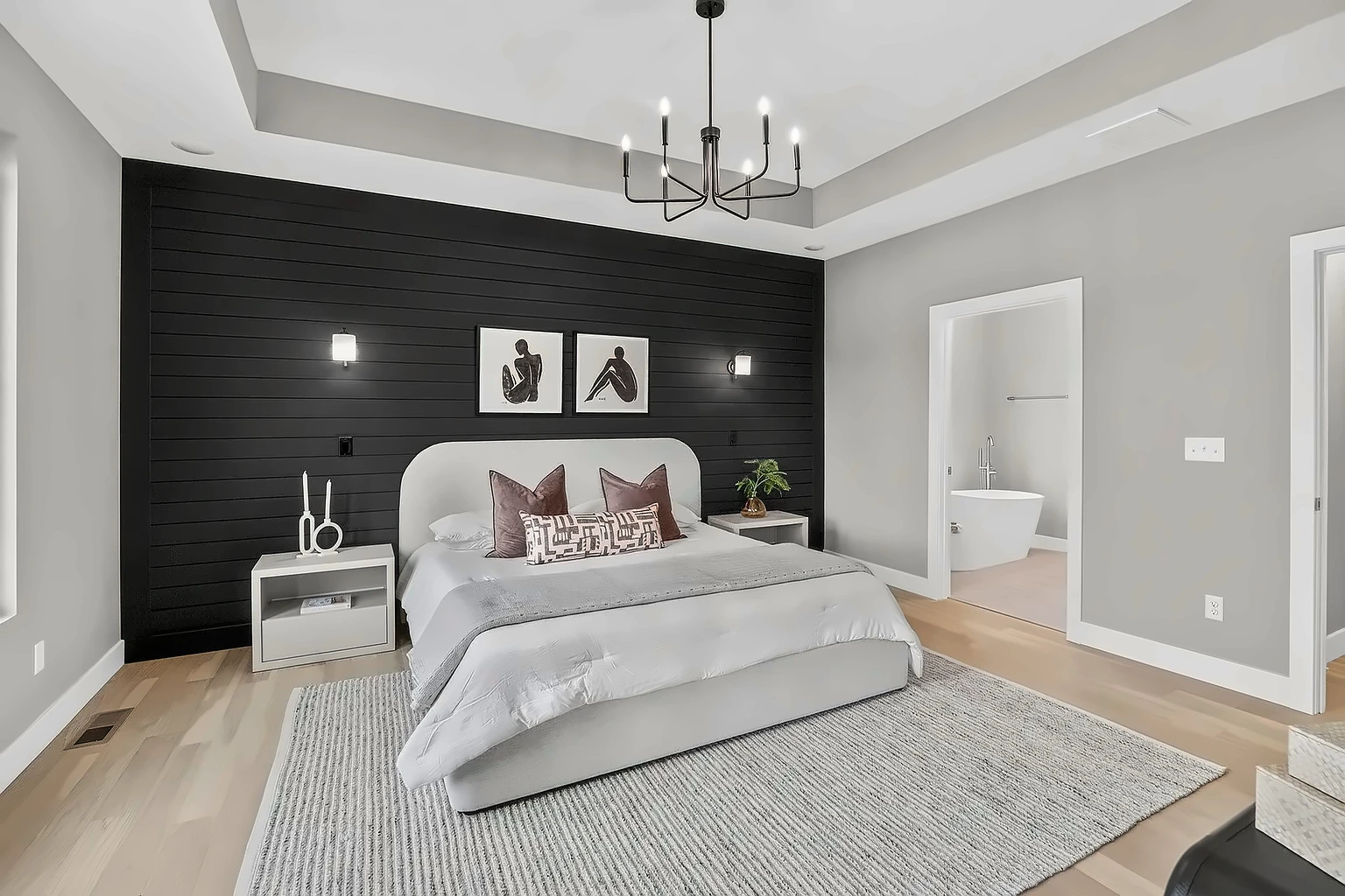 Primary bedroom with black shiplap wall and chandelier looking into the ensuite freestanding tub - 5048 Swale, Springfield, MO