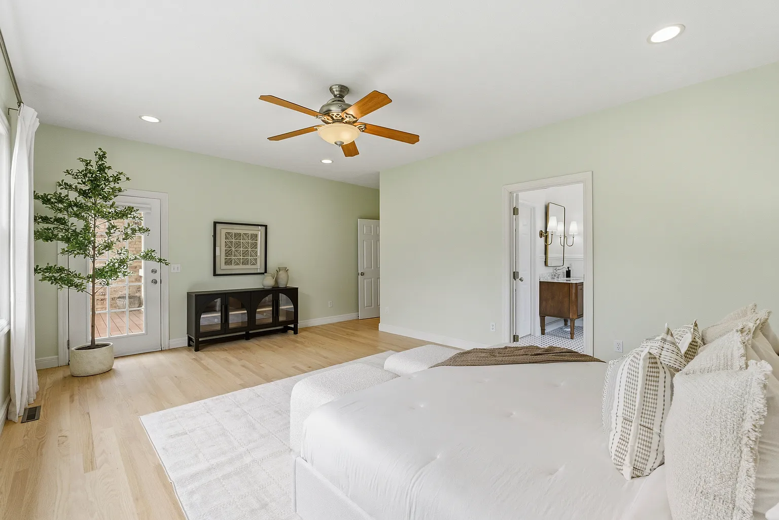 Primary bedroom from foot of bed with ensuite view and patio door - Gaslight Drive, Springfield, MO home staging