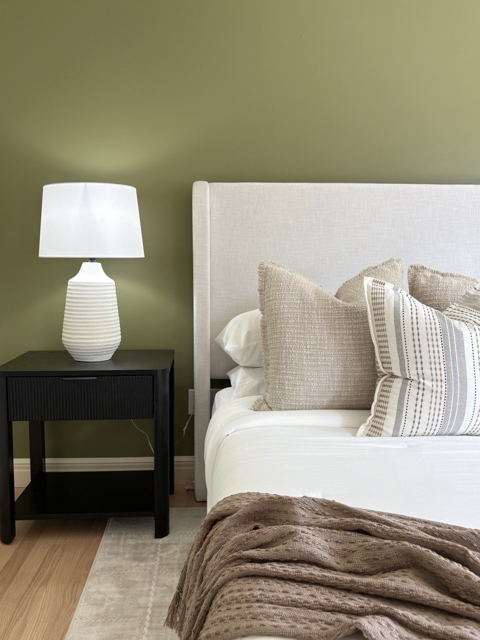 Primary bedroom upholstered headboard, layered pillows and black nightstand detail - Gaslight Drive, Springfield, MO