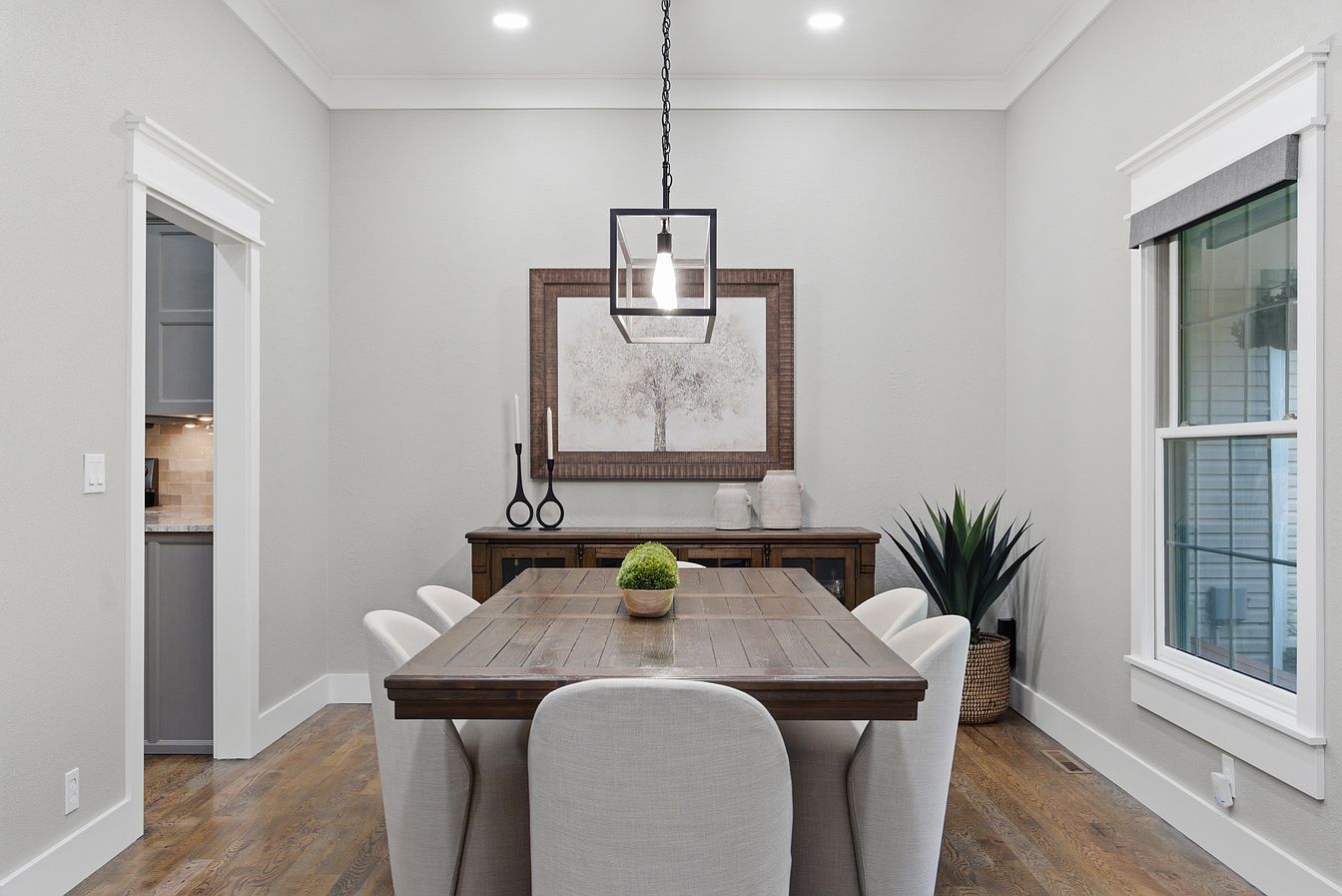 Formal dining room with wood trestle table, upholstered chairs and caged pendant light - Wilderness Road home staging, Rogersville, MO