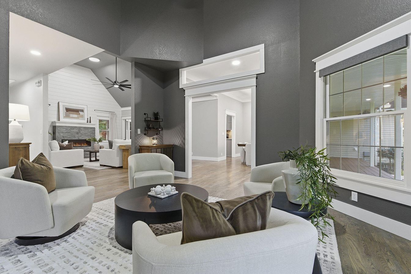 Charcoal sitting room with swivel chairs and round black coffee table looking into the great room - Wilderness Road, Rogersville, MO